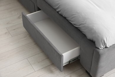 Storage drawer for bedding under modern bed in room