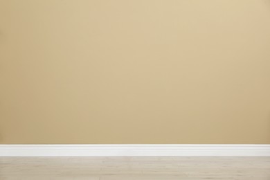 Photo of Empty room with beige wall and wooden floor