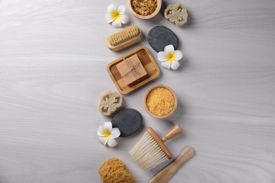 Photo of Flat lay composition with different spa products and flowers on light wooden table