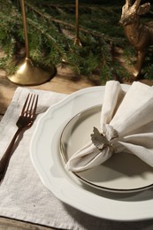 Photo of Stylish table setting with white fabric napkin, beautiful decorative ring and festive decor