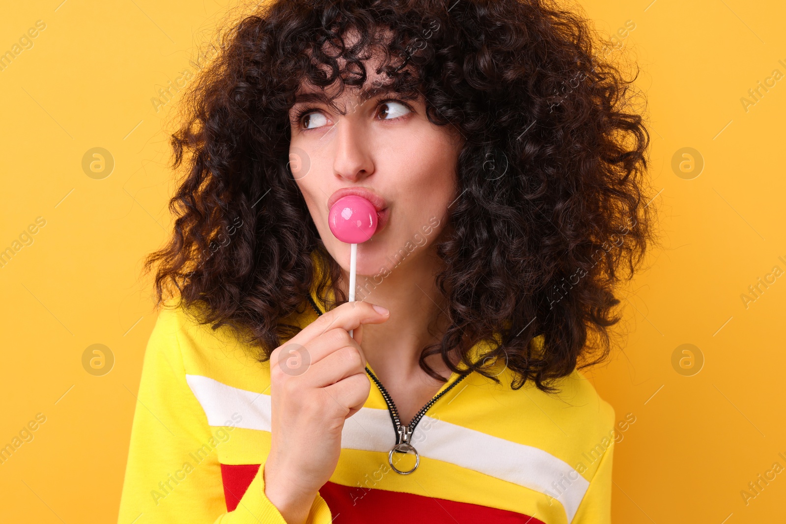 Photo of Beautiful woman with lollipop on yellow background