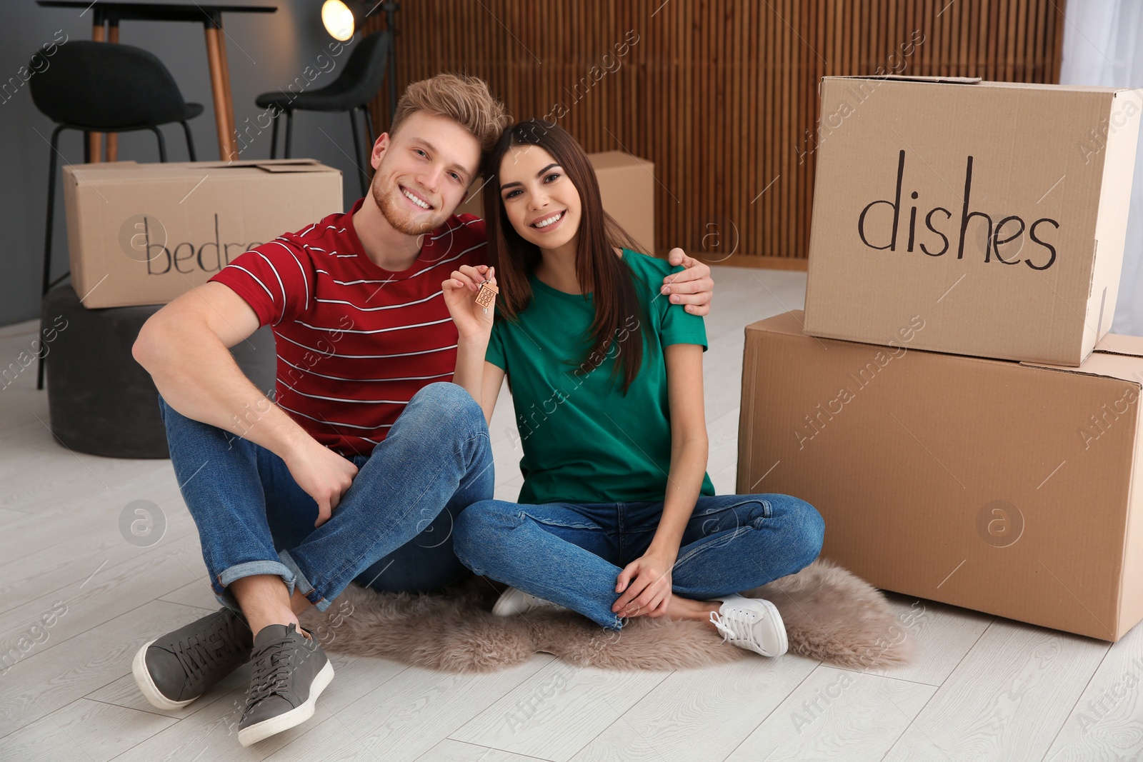 Photo of Young couple with key from their new house indoors. Moving day