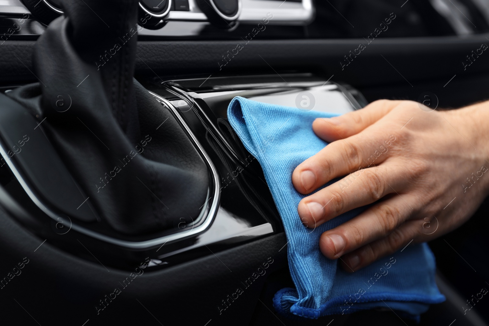 Photo of Car wash worker cleaning automobile interior, closeup