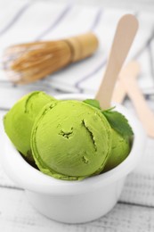 Photo of Tasty matcha ice cream in bowl on white wooden table