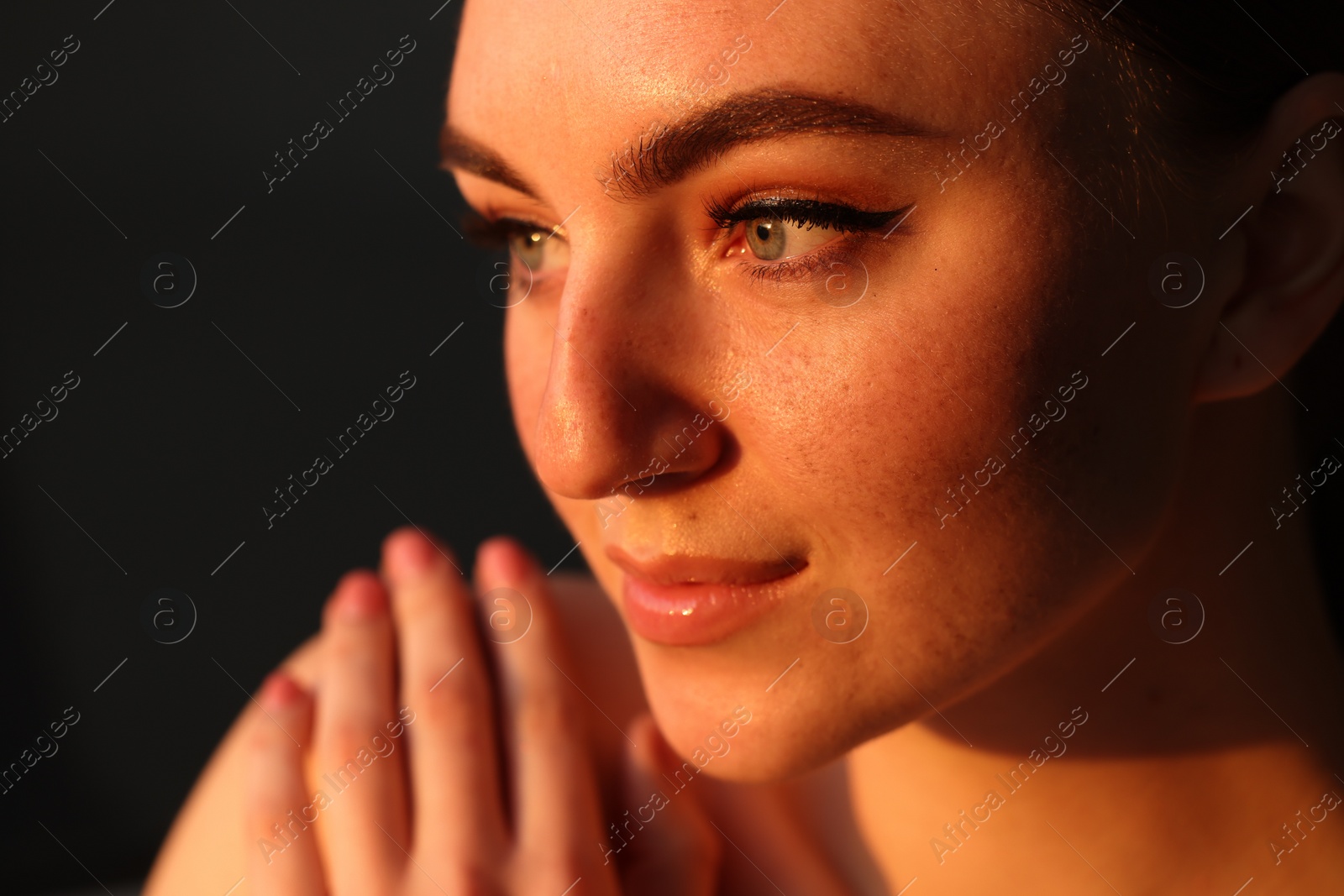 Photo of Fashionable portrait of beautiful woman with fake freckles on dark background, closeup