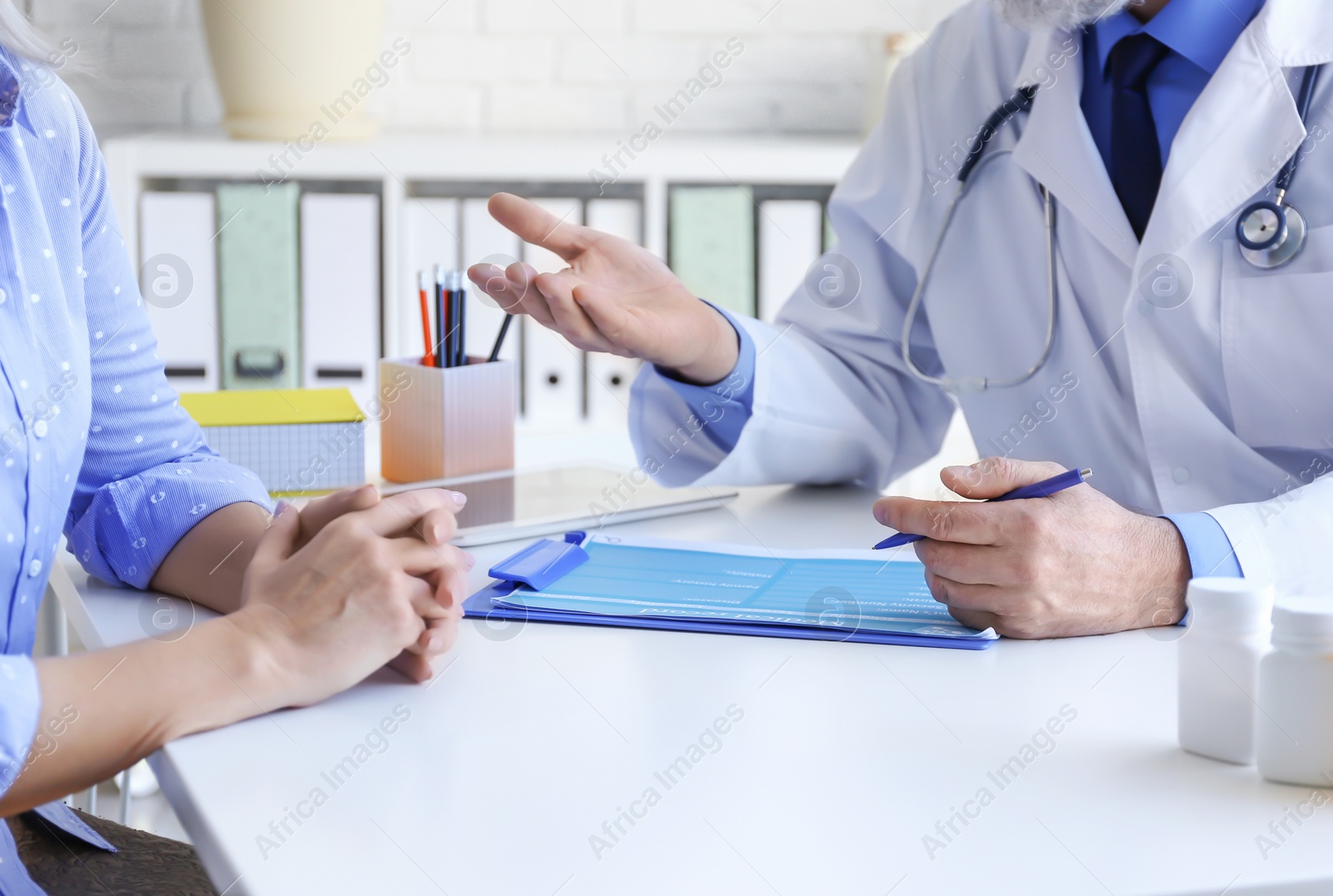 Photo of Mature doctor consulting patient in clinic