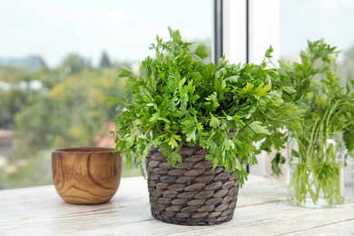 Photo of Wicker pot with fresh green parsley on window sill