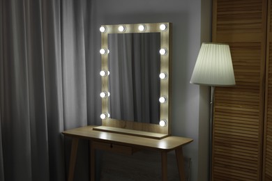 Beautiful mirror with light bulbs and lamp in makeup room