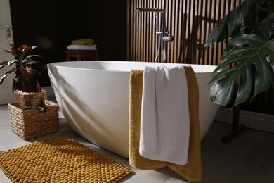 Photo of Cozy bathroom interior with stylish ceramic tub