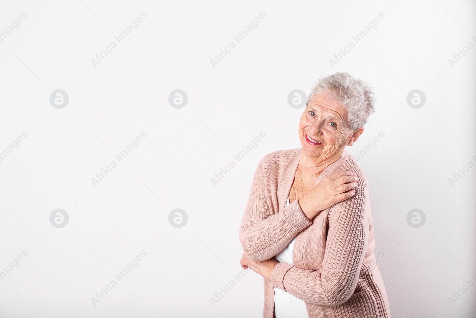 Photo of Portrait of grandmother in stylish clothes on light background, space for text