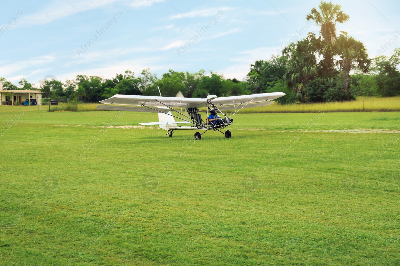 Photo of Man in light aircraft on green grass outdoors