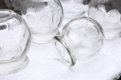 Glass cups on white towel, closeup. Cupping therapy