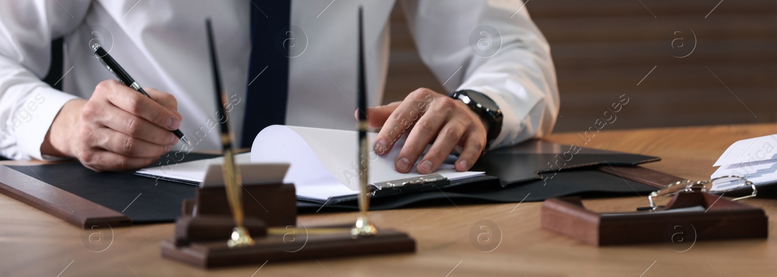 Image of Male notary working at table in office, closeup. Banner design