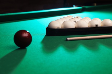 Photo of Billiard balls, triangle rack and cue on table