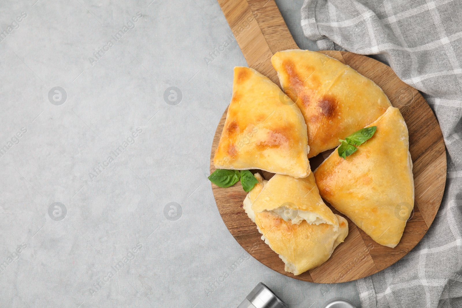Photo of Delicious samosas and basil on grey table, top view. Space for text