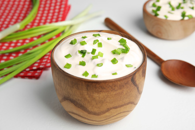 Photo of Fresh sour cream with onion on white table