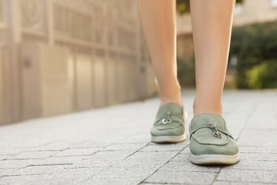 Woman in stylish loafers walking on city street, closeup. Space for text