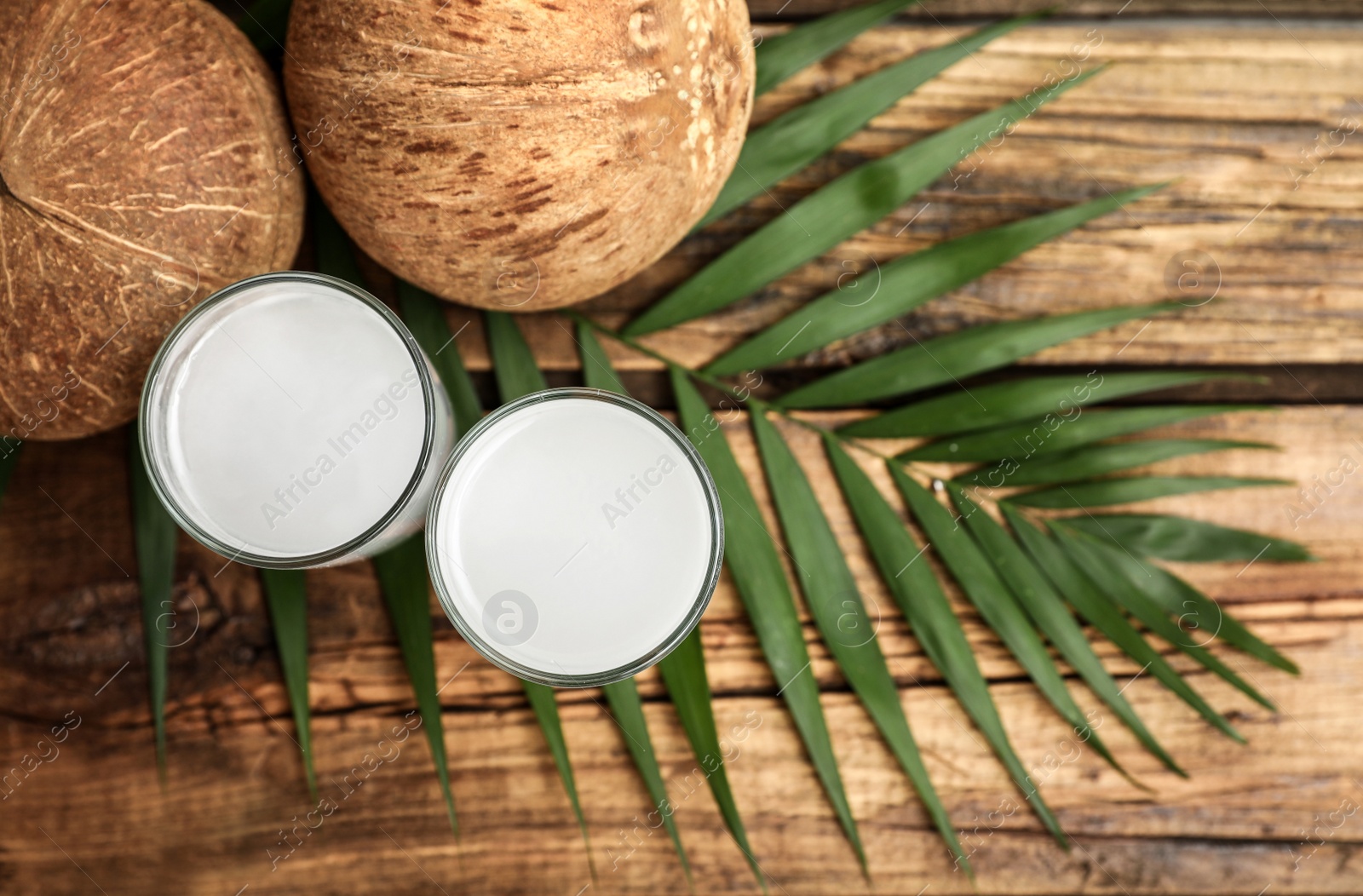 Photo of Flat lay composition with glasses of coconut water on wooden background