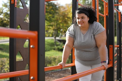 Photo of Beautiful overweight woman training on sports ground