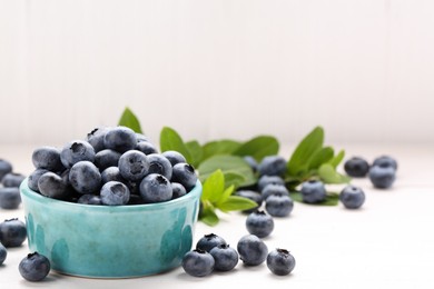 Photo of Tasty fresh blueberries on white table, closeup. Space for text