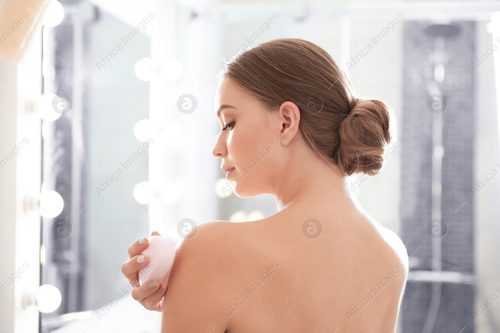 Photo of Young woman with soap bar in bathroom