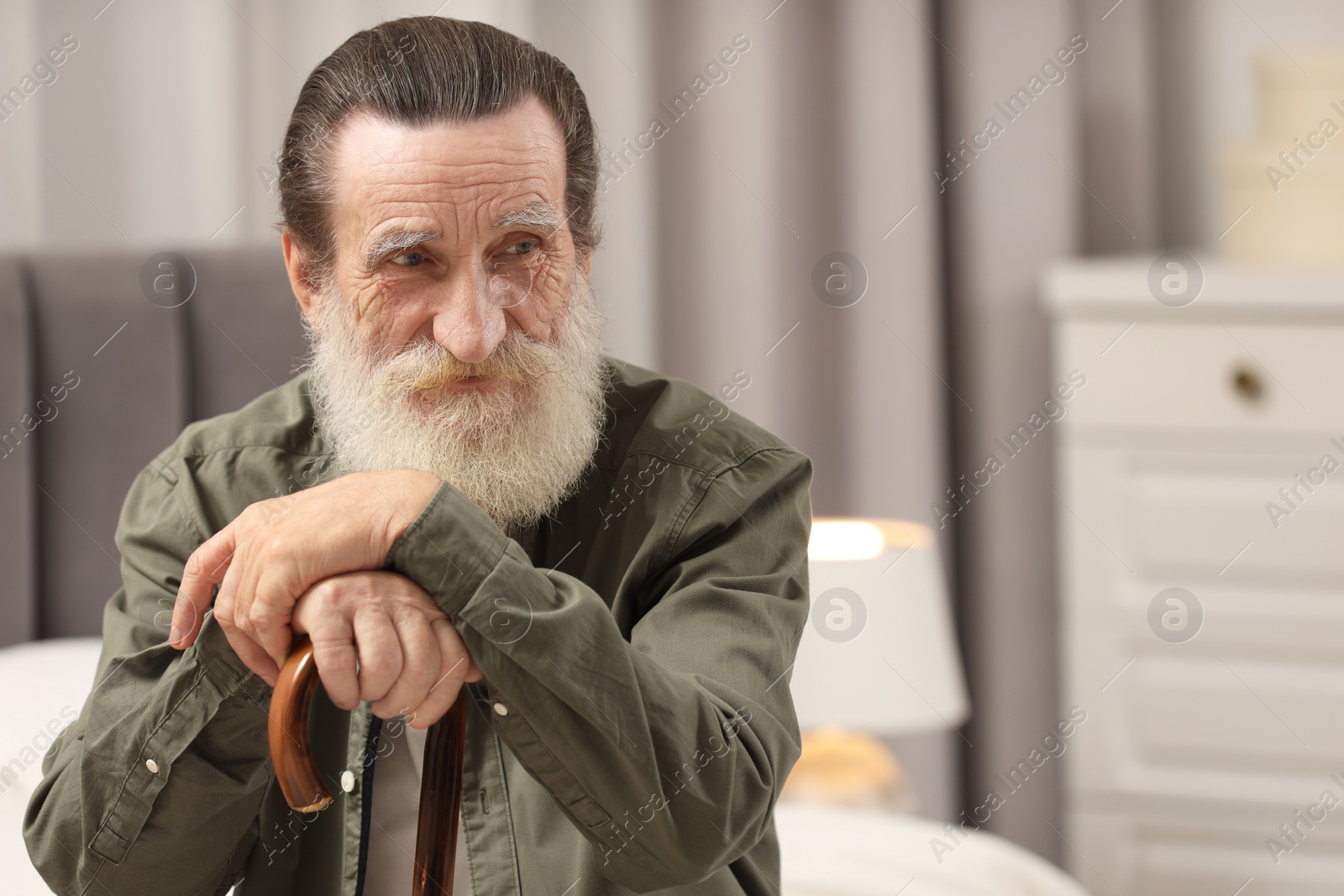 Photo of Senior man with walking cane at home