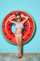Photo of Cute little girl with inflatable ring near color wall