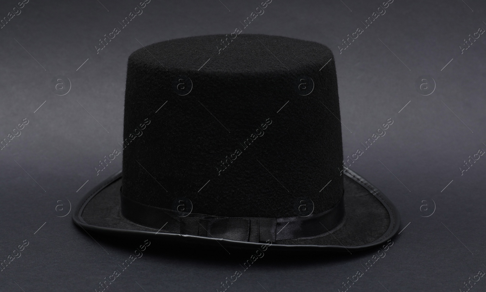 Photo of One magician top hat on dark grey background