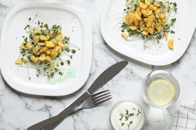 Photo of Delicious fresh carrot salads served on white marble table, flat lay