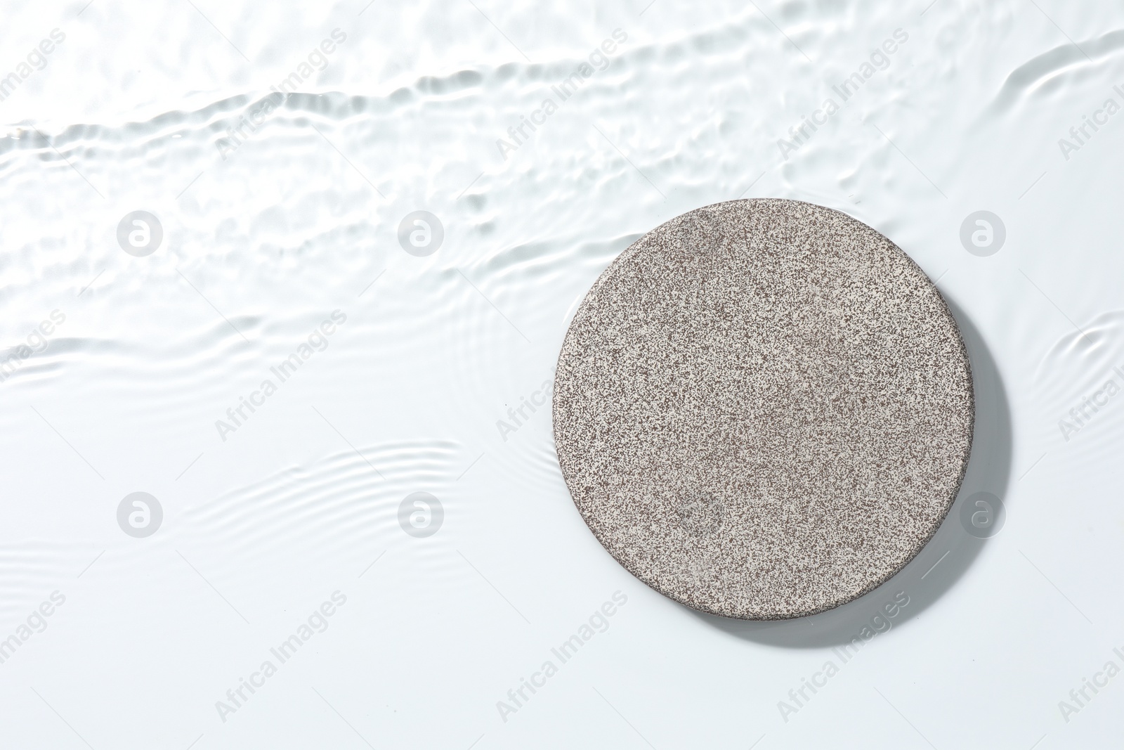 Photo of Presentation of product. Stone podium in water on white background, top view. Space for text