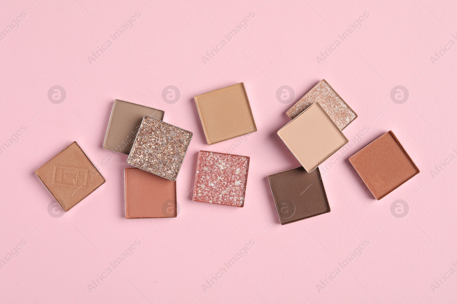 Photo of Different beautiful eye shadows on pink background, flat lay