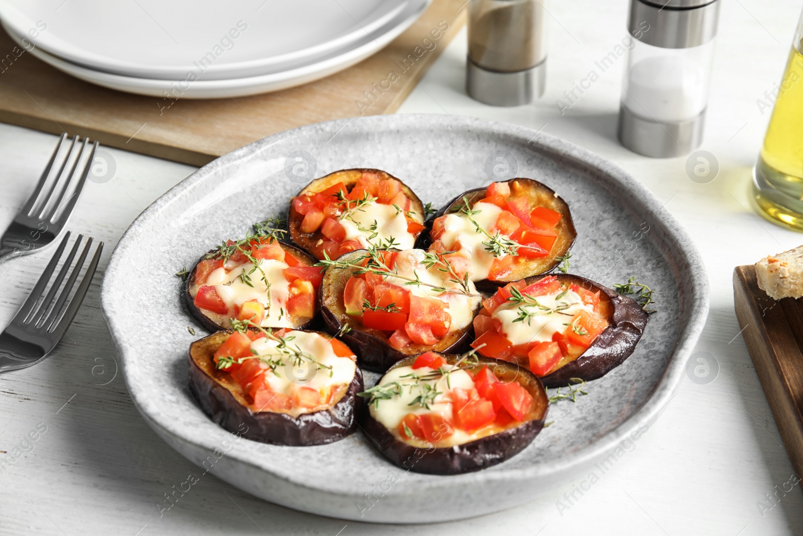 Photo of Baked eggplant with tomatoes, cheese and thyme on table