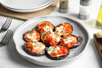 Photo of Baked eggplant with tomatoes, cheese and thyme on table