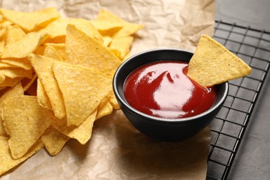 Photo of Tasty ketchup and tortilla chips on table, closeup