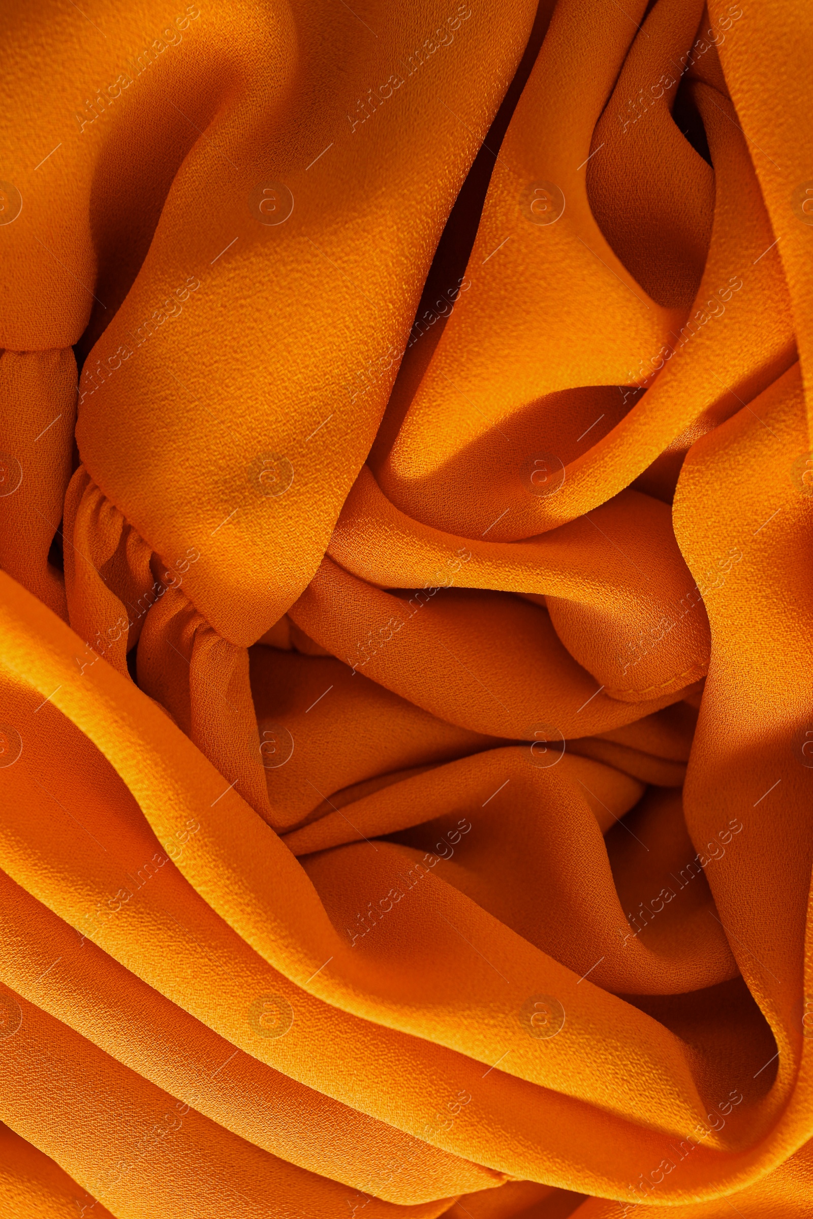 Photo of Texture of orange crumpled fabric as background, top view