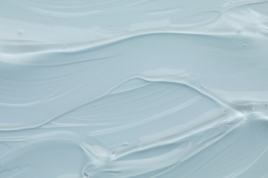 Photo of Clear cosmetic gel on light blue background, top view