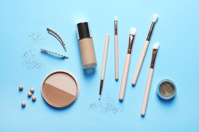 Photo of Flat lay composition with makeup brushes on light blue background
