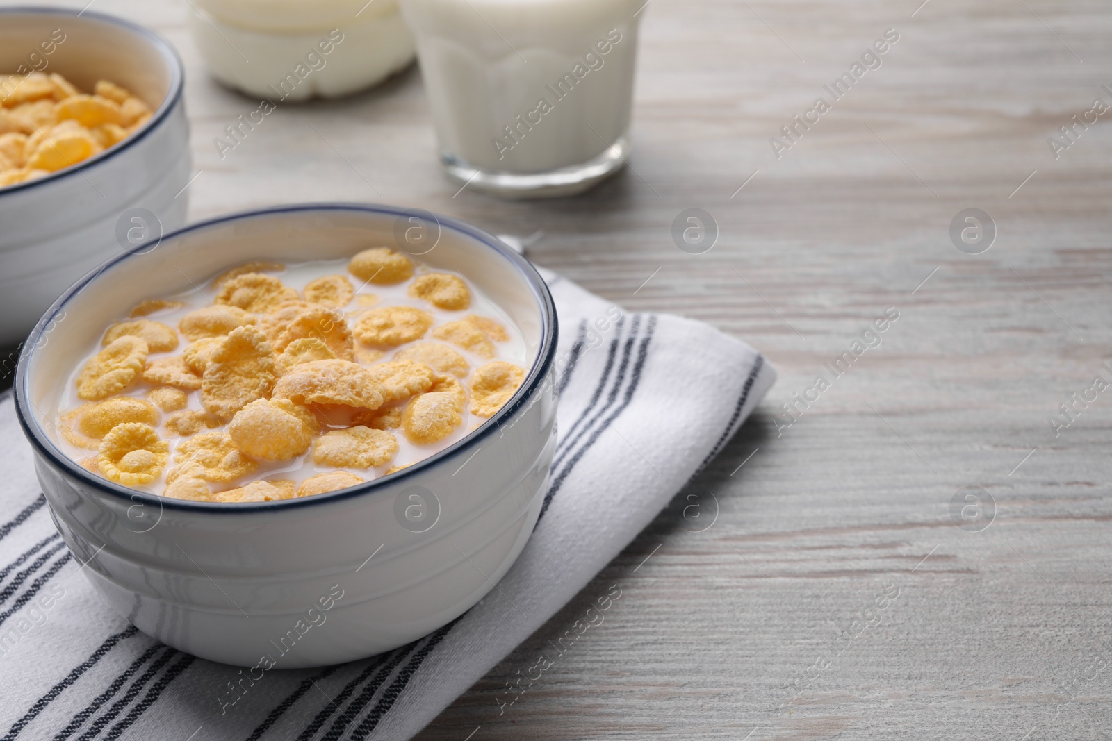 Photo of Tasty cornflakes with milk served on wooden table, space for text