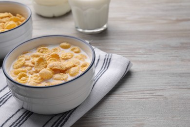 Photo of Tasty cornflakes with milk served on wooden table, space for text