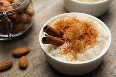 Photo of Delicious rice pudding with cinnamon on wooden table, closeup