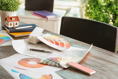 Photo of Color palette samples and house plan on table