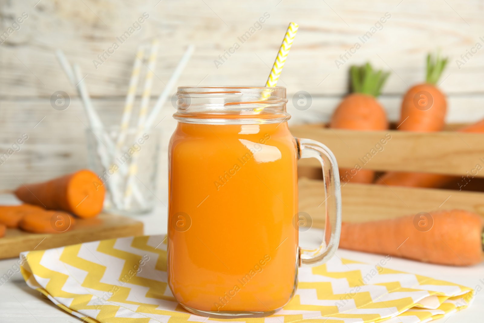 Photo of Freshly made carrot juice in mason jar on white table