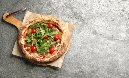 Tasty pizza with meat and arugula on grey table, top view. Space for text