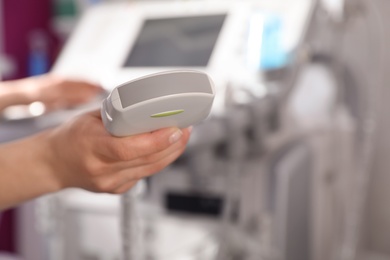 Sonographer holding ultrasound machine probe in clinic, closeup with space for text