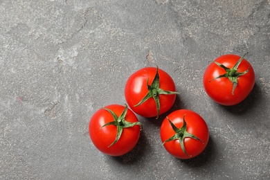 Photo of Fresh cherry tomatoes on stone background, top view