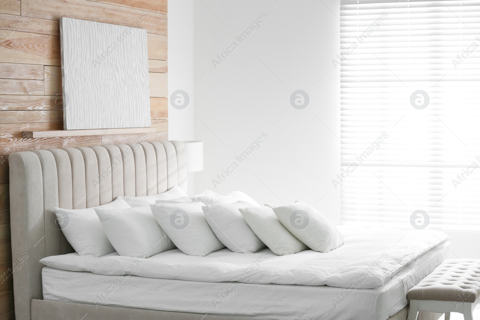 Photo of Comfortable bed with soft white pillows indoors