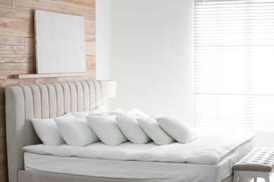 Photo of Comfortable bed with soft white pillows indoors