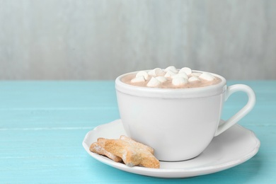 Composition with delicious cacao drink in cup on turquoise wooden background