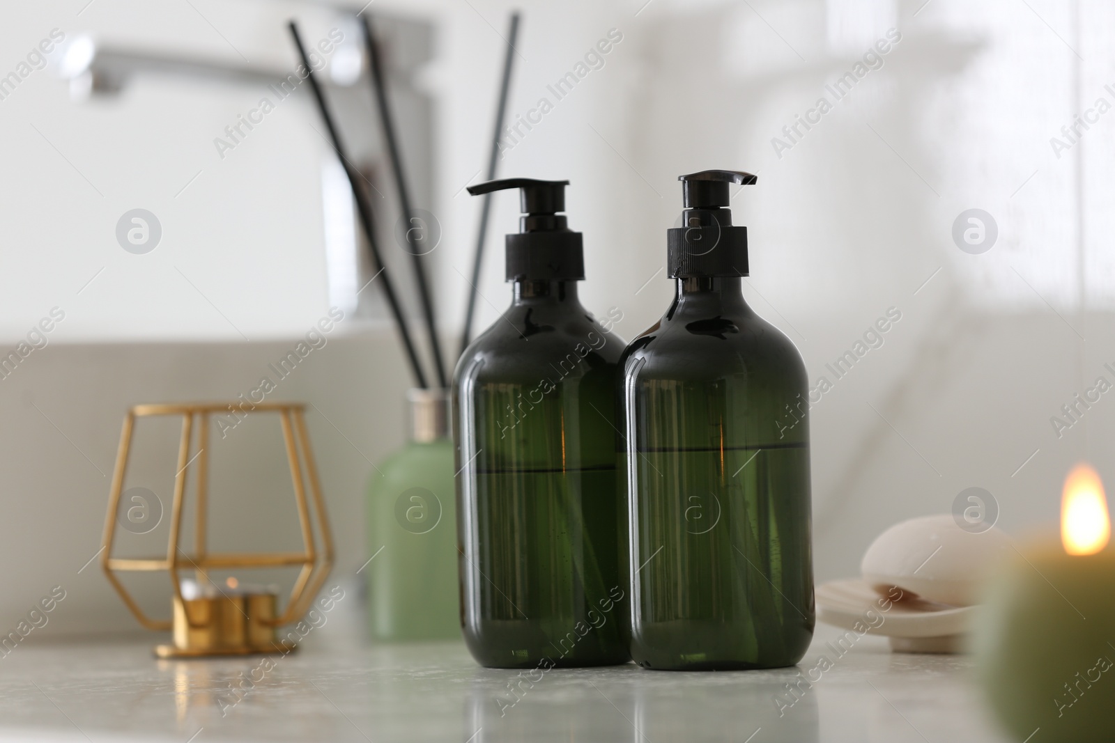 Photo of Green soap dispensers on white countertop in bathroom