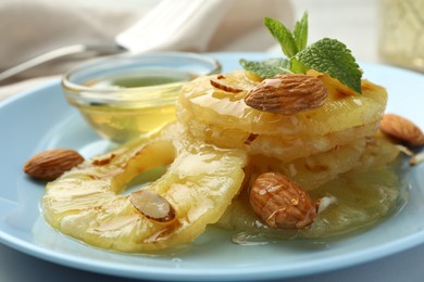 Photo of Tasty grilled pineapple slices, almonds and mint on table, closeup